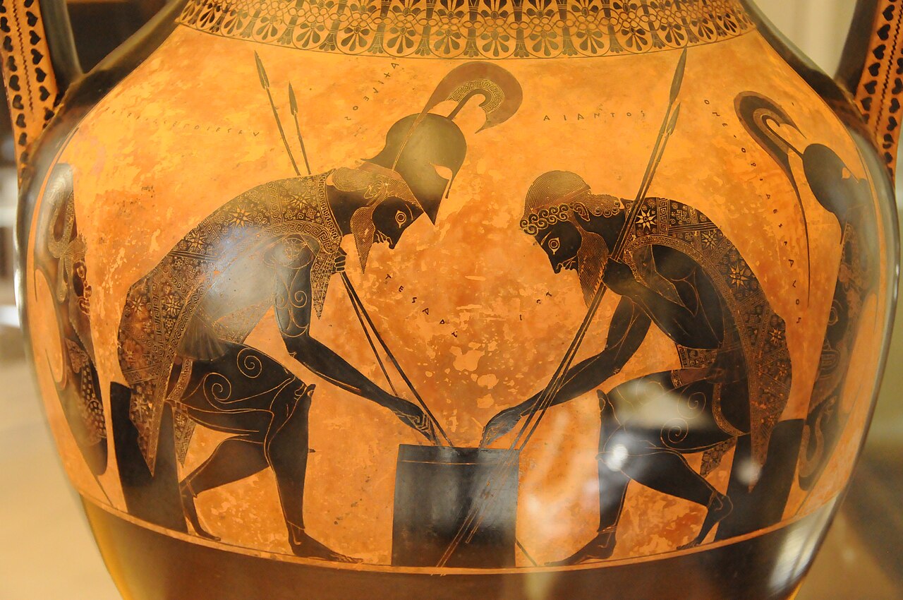 Two armored warriors on a black-figure pot, bent over a table and playing a game.
