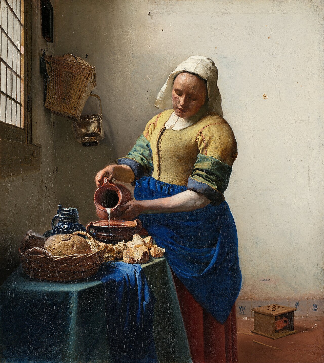 Johannes Vermeer, The Milkmaid, c. 1658. A woman in a blue apron and yellow bodice pours milk from a jug into a bowl.
