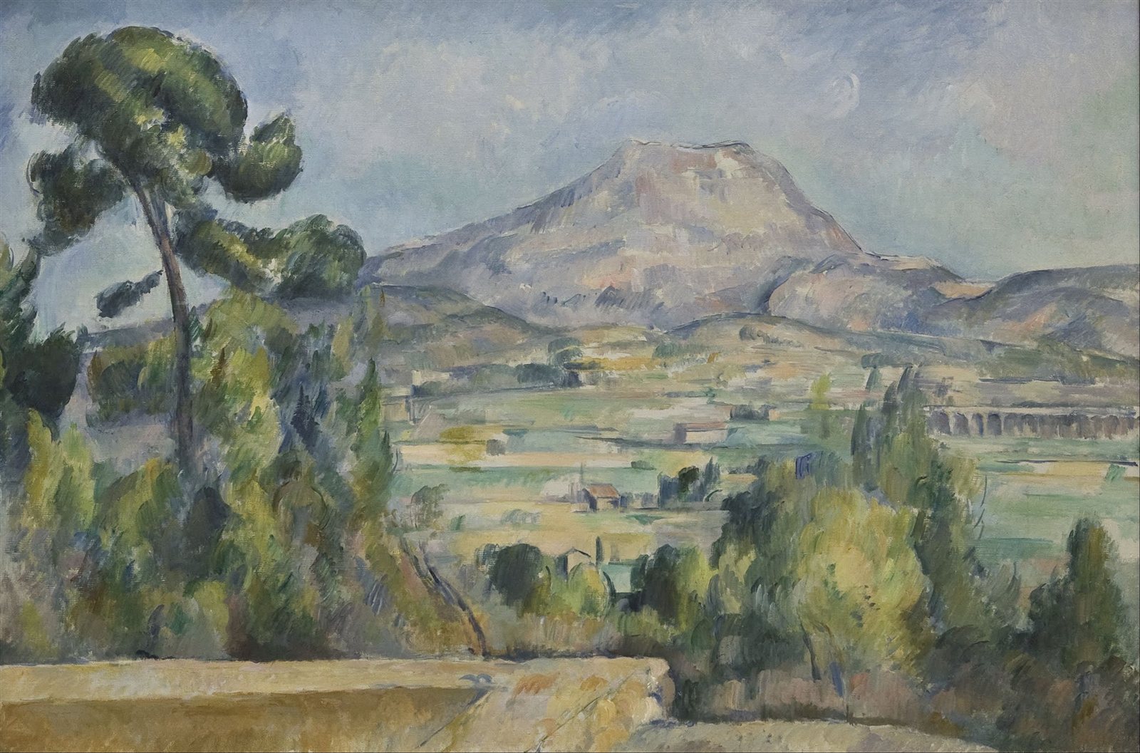 Paul Cézanne, Mont Sainte-Victoire, 1886-1887. An oil painting of a mountain in southern France rendered in patches of blue, green, and ochre.