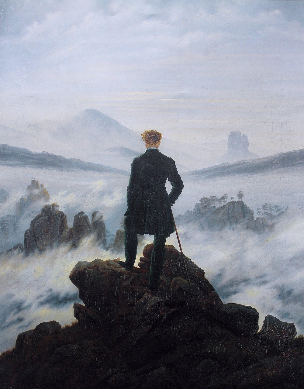 Caspar David Friedrich, Wanderer above the Sea of Fog, c. 1818. A lone figure in a dark coat stands on a rocky peak, viewed from behind, looking out over a vast landscape of mist and mountain ridges.