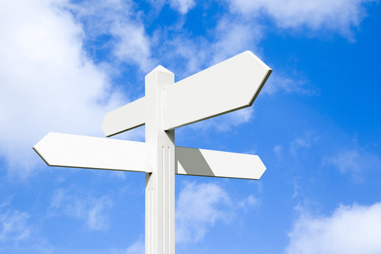 Photograph of a signpost at a crossroads, pointing in multiple directions.