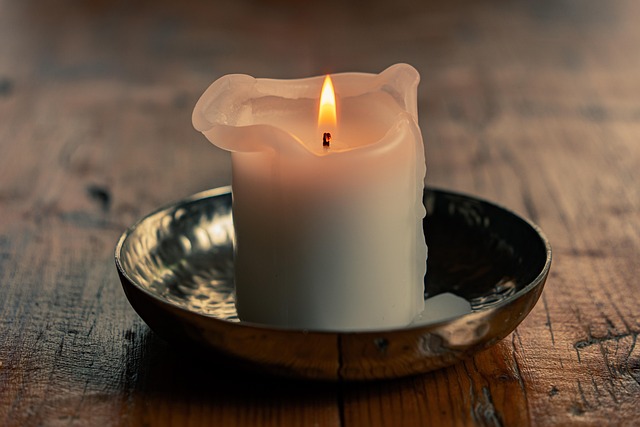 Photograph of a single lit candle on a wood table. The image evokes Kant's claim that the good will shines as the one unconditional good in a world where every other good can be put to bad use.