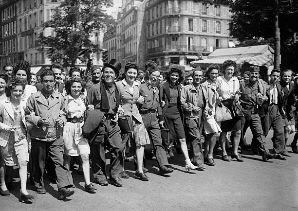 Photograph of a Paris street scene in the 1940s with demonstrators marching.