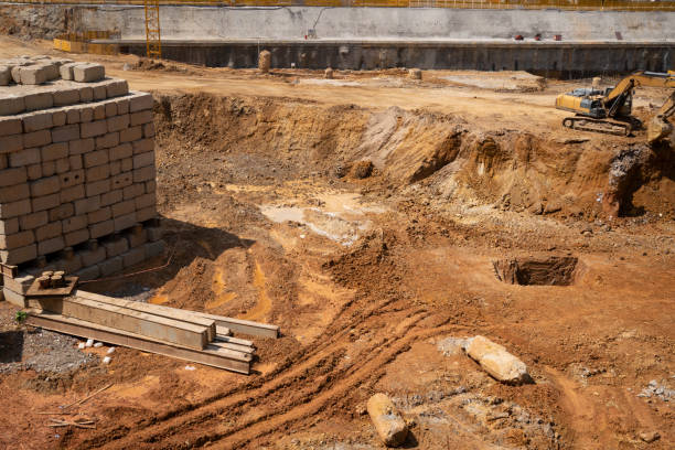 Photograph of an archaeological excavation showing distinct layers of soil and artifacts at different depths.