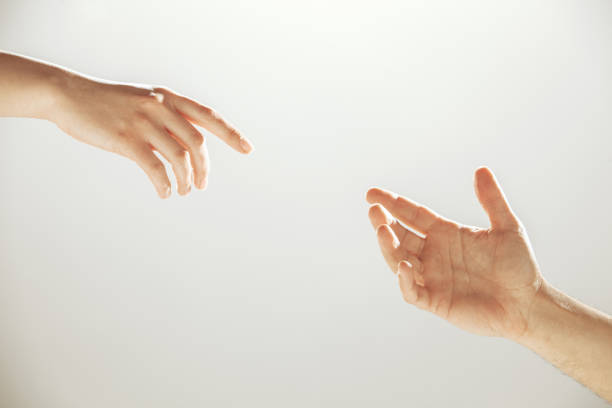Photograph of hands reaching out to one another in a gesture of mutual help.